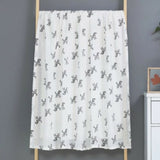 White muslin two layer baby swaddlewith black animal pattern .