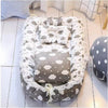 Gray foldable baby sleeping nest with a soft cloud pattern, cozy padded sides, breathable fabric, lightweight portable design, and a comfortable newborn-friendly interior.
