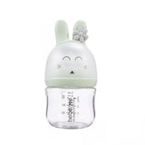 Anti colic feeding bottle with a green bunny-shaped cap .