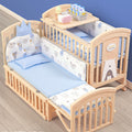 Wooden crib with baby bedding and accessories .