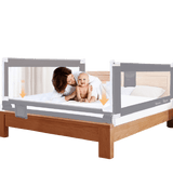 portable toddler bed with a gray safety rail and a baby and woman on the bed.