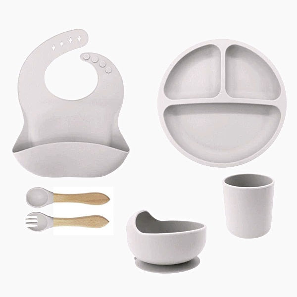 Set of gray baby feeding set including a bib, plate, cup, bowl, and spoons .