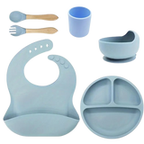 Set of blue silicone baby set including a bib, plate, cup, and spoons .