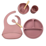 Pink baby silicone feeding set with bib, bowl, cup, and plate .