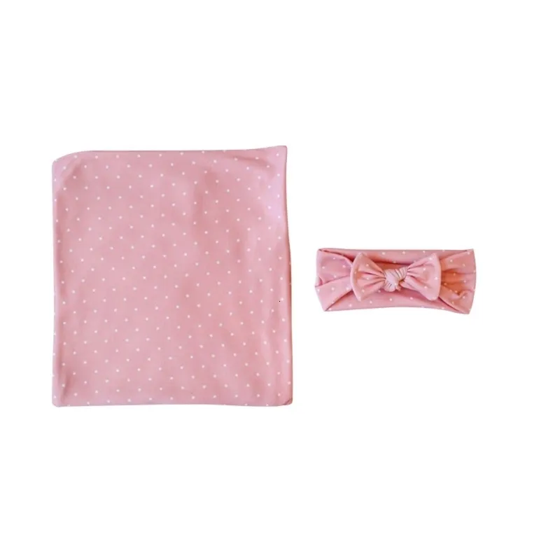 Pink polka dot swaddle blanket and matching headband wrap.