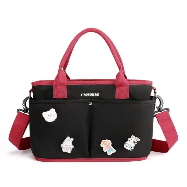 Black Baby Diaper handbag with pink handles and straps.