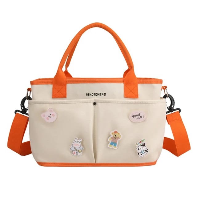 Beige and orange baby diaper Tote hand bag with cartoon characters.