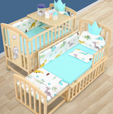 Wooden crib with baby bedding and accessories on a wooden floor.