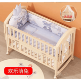 Wooden crib with baby bedding set featuring animal prints on a wooden floor.