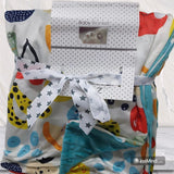 Colorful baby blanket with cartoon patterns and a visible brand label