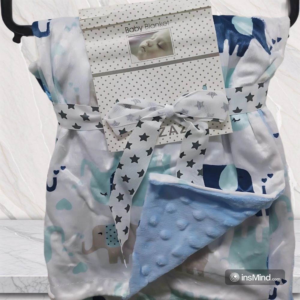 Baby blanket with elephant and star pattern, featuring a soft blue corner.