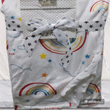 Baby blanket with rainbow and star patterns, tied with a ribbon.