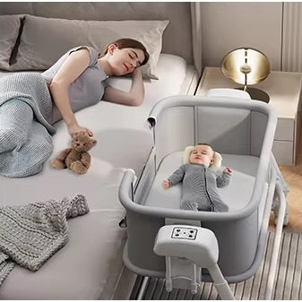 Woman lying on a bed with a baby in a portable baby swing crib .