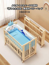 Wooden baby crib with blue bedding set and toys on a light wooden floor.