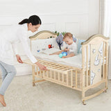 Woman adjusting a woodenbaby crib. 