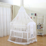 White baby crib with a canopy in a room with curtains and a bookshelf.