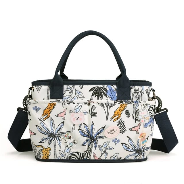Multicolored floral and animal patterned diaper bag with black straps.