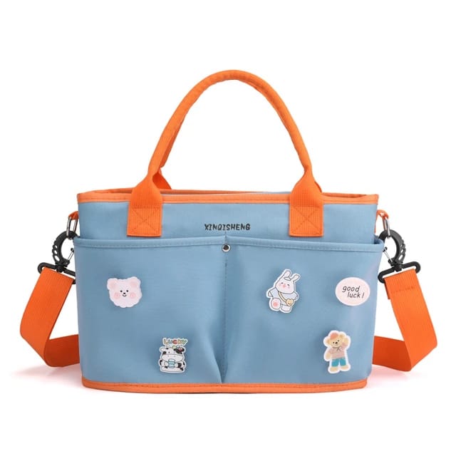 Blue bag with orange handles Tote Diaper Bag featuring cartoon stickers .