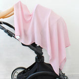 Black stroller with a pink color bamboo cotton baby swaddle blanket. 