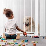 Child sitting on the floor with a dog behind a Bay bee Auto safety gate, surrounded by toys.