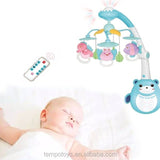 Baby sleeping next to a colorful baby bear bell crib mobile with remote. control