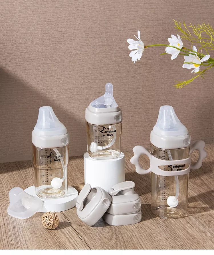 Set of  breast milk baby bottles with accessories on a with a floral decoration.