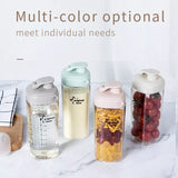 Set of four colorful water bottles with different designs on a marble surface.