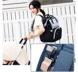 Woman with a black backpack holding a baby stroller, with close-up details of the backpack.
