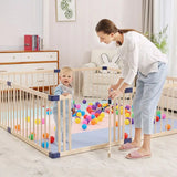 Child playing with colorful balls inside a wooden foldable playpen in a bright, cozy room.
