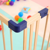 Wooden foldable playpen featuring a protective corner cover, with colorful balls scattered inside the playpen.