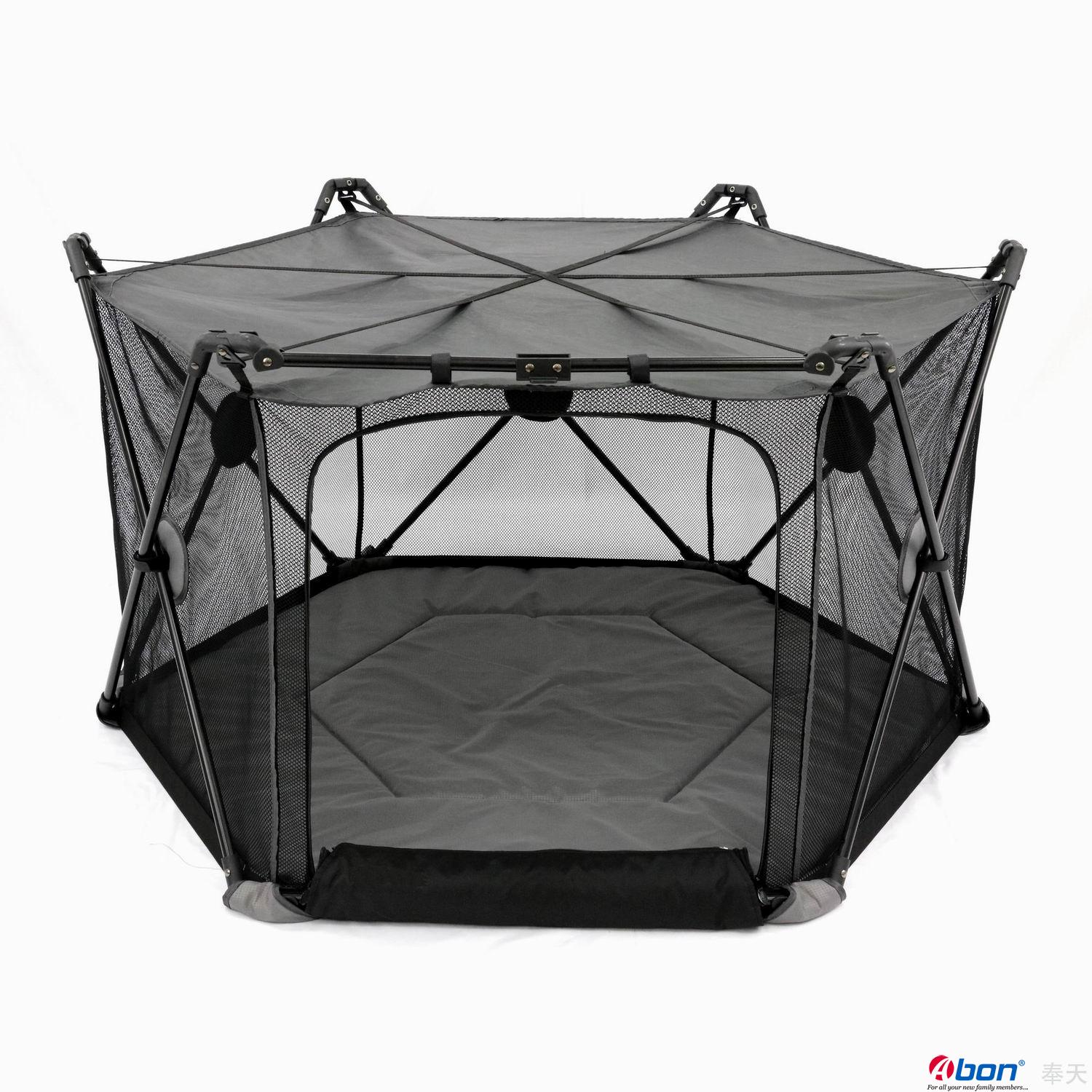 Black hexagonal MagicGo baby playpen with mesh sides, a padded floor, and a sturdy support frame.



