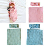 Baby wrapped in pink blanket with headband, surrounded by additional baby items including green and blue blankets and headbands.