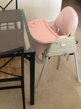 Pink and beige portable plastic baby dining high chair.