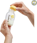 Person holding a Medela bottle with a yellow cap 