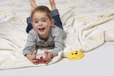 Child lying on a white blanket with a Meli snack container lionking