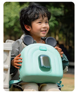 Child holding a green mickey mouse bag.