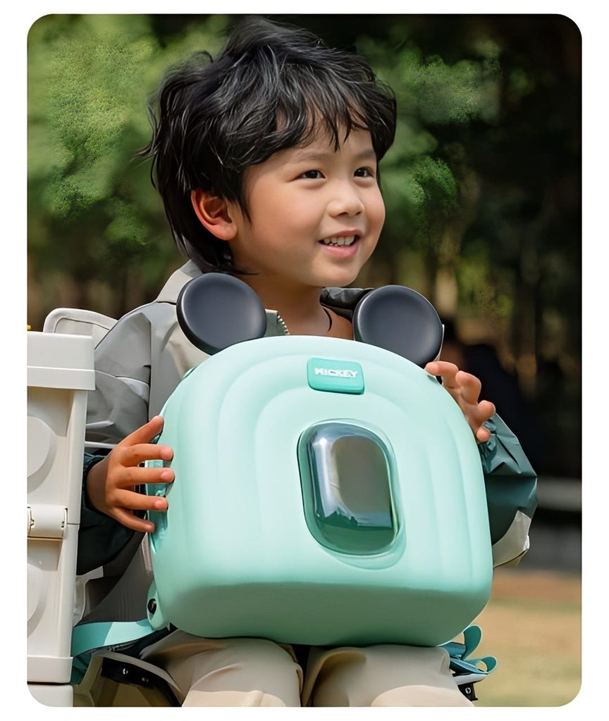 Child holding a green mickey mouse bag.