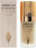 Charlotte Tilbury Airbrush Flawless Foundation bottle next to its beige and gold packaging box, featuring the brand's signature diamond logo.